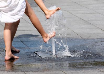 Kinder spielen mit Brunnen